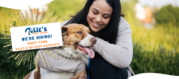 outdoor background, dark haired woman kneeling, hugging a brown and white collie mix dog. Snippet of a flyer advertising Liz's Pet Shop hiring a part-time sales and delivery position. 2 buttons linking to career and employment  pages